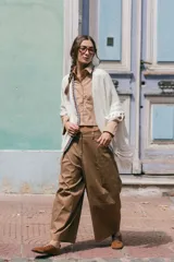 Poncho liviano de tejido de punto color blanco, con bordes decorados en crochet multicolor y flecos en el ruedo.