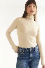 Polera de algodón color bordó, con cuello alto y mangas largas. Presenta un diseño ajustado al cuerpo con costuras visibles en los puños.