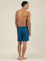 Short de baño azul petróleo de tejido Seersucker con elástano, con botón oculto a presión, elástico en la cintura trasera, dos bolsillos laterales y trasero con cierre, y suspensor de malla fina hipoalergénico.