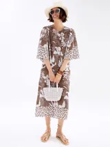 Vestido marrón con estampado floral blanco y detalles animal print en ruedo y mangas.