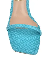 Sandalia negra con estampado de piel de serpiente, con dos tiras finas sobre el pie, pulsera al tobillo con hebilla y taco cuadrado mediano.