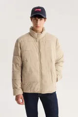 Campera puffer color beige con cierre frontal y cuello alto.
