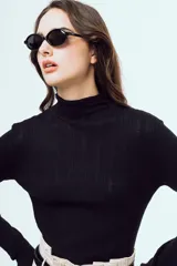 Top de punto negro con cuello alto, diseño al cuerpo y mangas largas, confeccionado con textura acanalada.