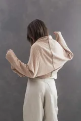 Saco tipo capa de lanilla con diseño de rayas horizontales en tonos arena, chocolate y bordó. Presenta mangas amplias y cierre frontal mediante alamar de cuero color suela con detalle en carey.