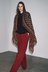 Pañuelo cuadrado de mezcla de tejidos y lana, color marrón oscuro con estampado de lunares beige. Presenta un borde con franjas y lunares más pequeños, y terminaciones deshilachadas.