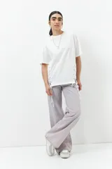 Remera blanca de algodón con cordones ajustables a los laterales, manga corta y cuello redondo.