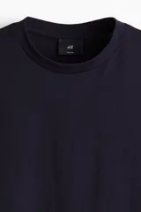 Remera de algodón color negro, con cuello redondo y mangas cortas, de corte estándar.