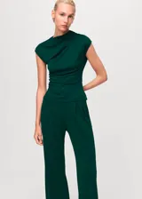 Pantalón de vestir color verde oscuro, de corte wide leg y tiro medio. Presenta cintura con elástico, pinzas delanteras y diseño largo.