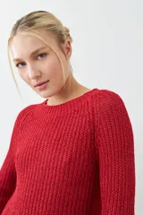 Sweater tejido de punto color rojo con cuello redondo y ruedo curvo.