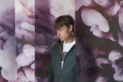 Campera verde oscuro con capucha, cierre frontal y bolsillos laterales.