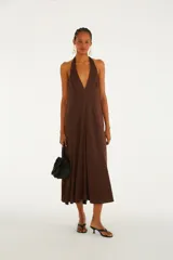 Vestido midi marrón con escote pronunciado en V y tirantes halter, de silueta fluida.