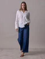 Camisa blanca a rayas verticales, marca Alex & Jordan. Tiene cuello con solapa, abertura central con botones y bolsillo aplicado en el pecho.