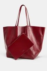 Bolso tipo shopper de cuero en color bordó, con diseño amplio y asas largas para el hombro.