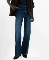 Jeans de denim azul de corte wide leg, tiro medio y diseño clásico de cinco bolsillos con cierre frontal de botón y cremallera.