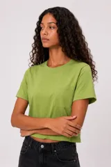 Remera verde de manga corta, confeccionada en algodón, con cuello redondo a la base y un bolsillo aplicado en el pecho. Diseño holgado.