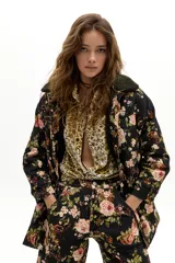 Chaqueta de denim con estampado floral vintage, corte oversized, cuello y forro interior de corderito en color verde oscuro. Cuenta con cinco bolsillos delanteros y cierre de botones metálicos ocultos.