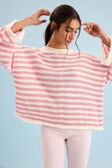 Buzo tejido de algodón con diseño a rayas horizontales en color crudo y rosado, cuello redondo y mangas anchas.