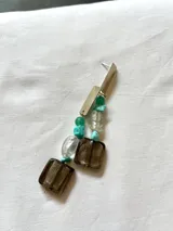 Aros largos colgantes con base de alpaca y cuentas de vidrio y piedras de colores verde, turquesa, transparente y marrón.