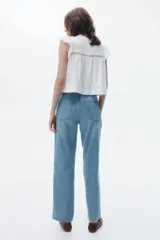 Jean de tiro alto con corte recto y holgado, confeccionado en denim rígido de cinco bolsillos con cierre de botón.