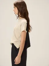 Remera negra de punto fino, con mangas cortas, cuello redondo y corte relajado. Cuenta con costuras verticales decorativas en el frente.