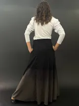 Falda larga de lana color negro con teñido degradado en tonos grises. Corte a la cintura con bolsillos laterales y cierre invisible.