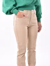 Pantalon de corte recto y tiro alto, confeccionado en material sintético con acabado tipo cuero en color beige. Presenta diseño clásico de cinco bolsillos, cierre frontal con botón y costuras reforzadas.