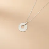Collar de cadena fina tipo veneciana con dije circular de diseño texturizado con líneas radiales, elaborado en plata 925.