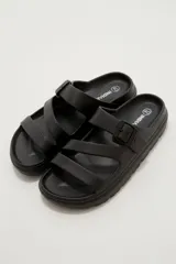 Sandalias de goma color negro con diseño de tres tiras cruzadas y hebilla lateral ajustable.