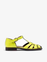 Sandalias tipo guillermina Bliss de cuero charol color amarillo, con capellada entretejida, tira en T y cierre de hebilla lateral. Posee suela plana y taco bajo.