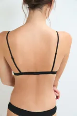 Conjunto de ropa interior compuesto por un corpiño triangular y una bombacha clásica, ambos en color negro con detalles de puntilla en los bordes.