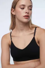 Sostén tipo bralette color beige, de tela acanalada, con breteles ajustables, doble tela y espalda con broche de tres medidas. Sin relleno ni aro.