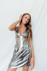 Vestido corto negro con escote en V, breteles finos cruzados en la espalda y cut-outs laterales bajo el busto.