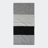 Cuello multifuncional Buff de lana merino, color gris con bloques de color blanco y negro.