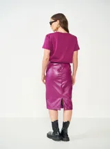 Falda tubo violeta de cuero sintético, corte a la rodilla.