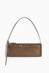 Cartera rectangular de hombro, color marrón topo, con textura de gamuza o nobuck. Presenta un cierre superior y una tira decorativa frontal con herraje metálico dorado tipo brida de caballo. Incluye correa larga ajustable para llevar al hombro.