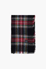 Pashmina de diseño cuadrado con estampado de cuadros escoceses en tonos negro, rojo, verde y amarillo. Presenta bordes con flecos y una etiqueta pequeña con logo en una de sus esquinas.