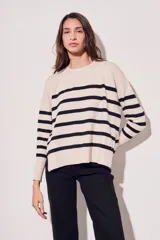Sweater beige con rayas horizontales negras, de corte holgado y mangas largas.