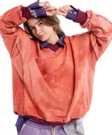 Buzo de algodón y cáñamo con escote en V, de calce relajado y diseño con cortes estructurales en cuerpo y mangas. Presenta puños y cintura tejidos en color bordó, contrastando con el tono naranja desgastado del cuerpo.