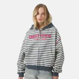 Campera con cierre y capucha, de calce oversize, con diseño de rayas horizontales en tonos blanco roto y gris/azul oscuro. Presenta un estampado frontal en rojo con el texto "EMESTUDIOS" y debajo "Always Grateful".