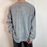 Buzo de cuello redondo con corte oversize, confeccionado en tela con efecto lavado ácido. Presenta costuras reforzadas visibles y una pequeña etiqueta con logo en el puño.