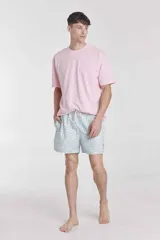 Short de baño celeste con estampado de margaritas, cintura elástica con cordón ajustable y bolsillos laterales.
