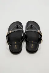 Sandalias negras de eco cuero estilo chunky, con diseño de tiras cruzadas y hebilla metálica dorada en la parte superior. Cuenta con tira ajustable en el talón.