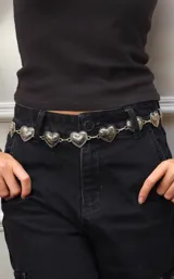 Cinto plateado con eslabones en forma de corazón y cadena colgante.