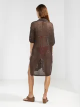 Camisa larga negra de punto calado con cuello camisero, manga tres cuartos y cierre frontal con botones.