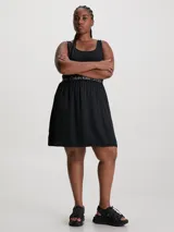 Vestido negro de punto acanalado elástico en la parte superior con escote cuadrado y espalda de nadador. La falda es de crepé tejido con vuelo y la cintura elástica lleva el logo repetido de Calvin Klein Jeans.