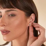Aros tipo caravana de oro 18k con esmeralda central en corte ovalado rodeada por un halo de brillantes.