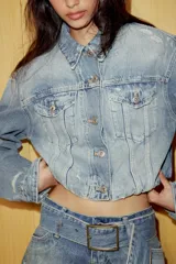 Shorts mini de tiro bajo confeccionados en denim azul con efecto desgastado y roturas. Presentan trabillas, bolsillos delanteros y un cinturón ancho integrado del mismo tejido con hebilla metálica.
