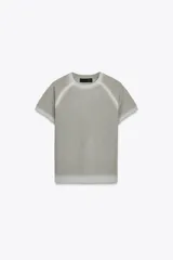 Top de punto gris claro con cuello redondo y manga corta, presentando un efecto degradado o desteñido en el cuello, hombros y ruedo.
