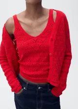 Cardigan de punto fino color rojo con diseño calado de crochet, escote en V y cierre frontal con botones.