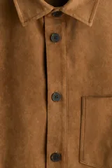 Sobrecamisa de H&M en tejido de efecto gamuza color marrón, con cuello inglés, cierre frontal de botones, un bolsillo en el pecho y mangas largas con puños abotonados.